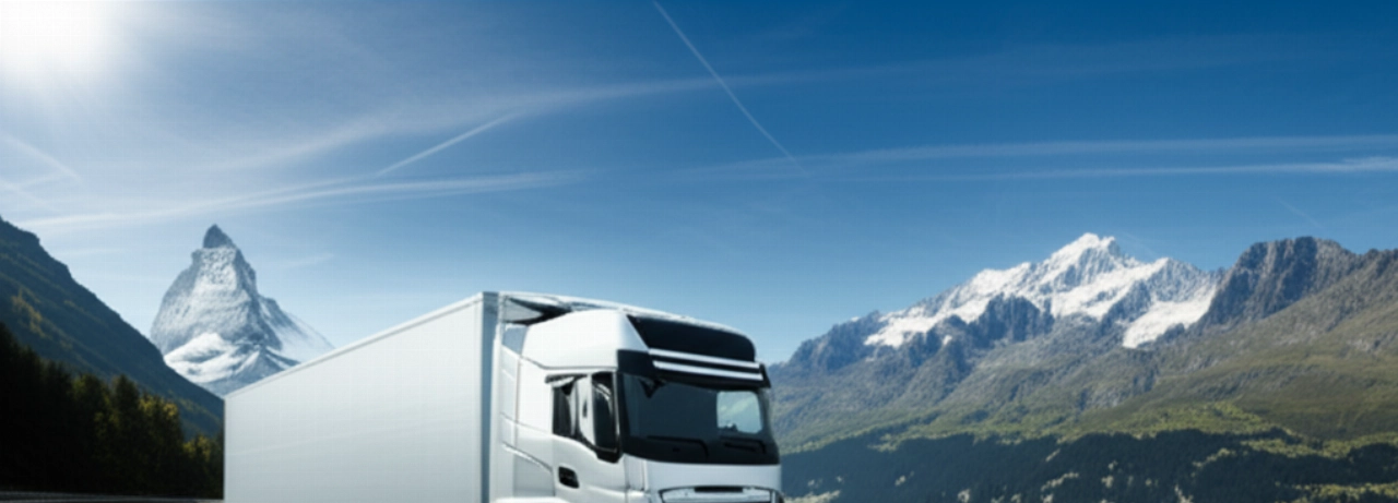 Camion de déménagement moderne voyageant sur une autoroute panoramique avec les Alpes suisses.